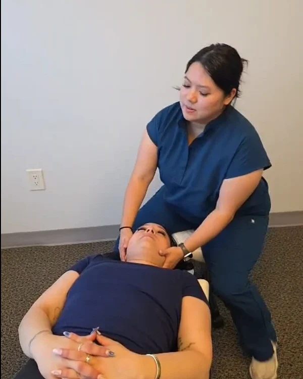 A chiropractor at Mani Chiropractic Clinic gently adjusting a patient’s neck