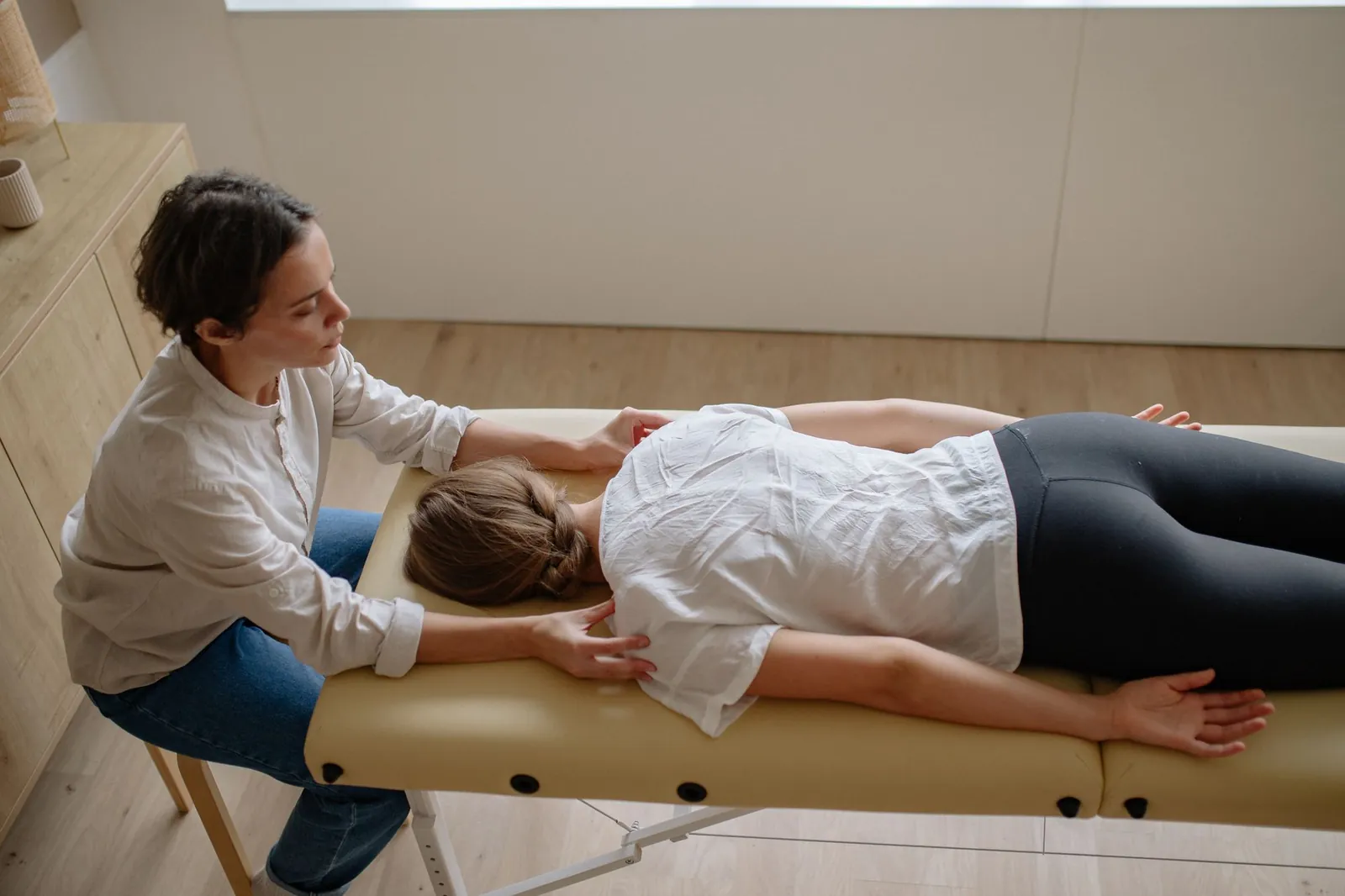 Therapist treating a patient in a bright treatment room