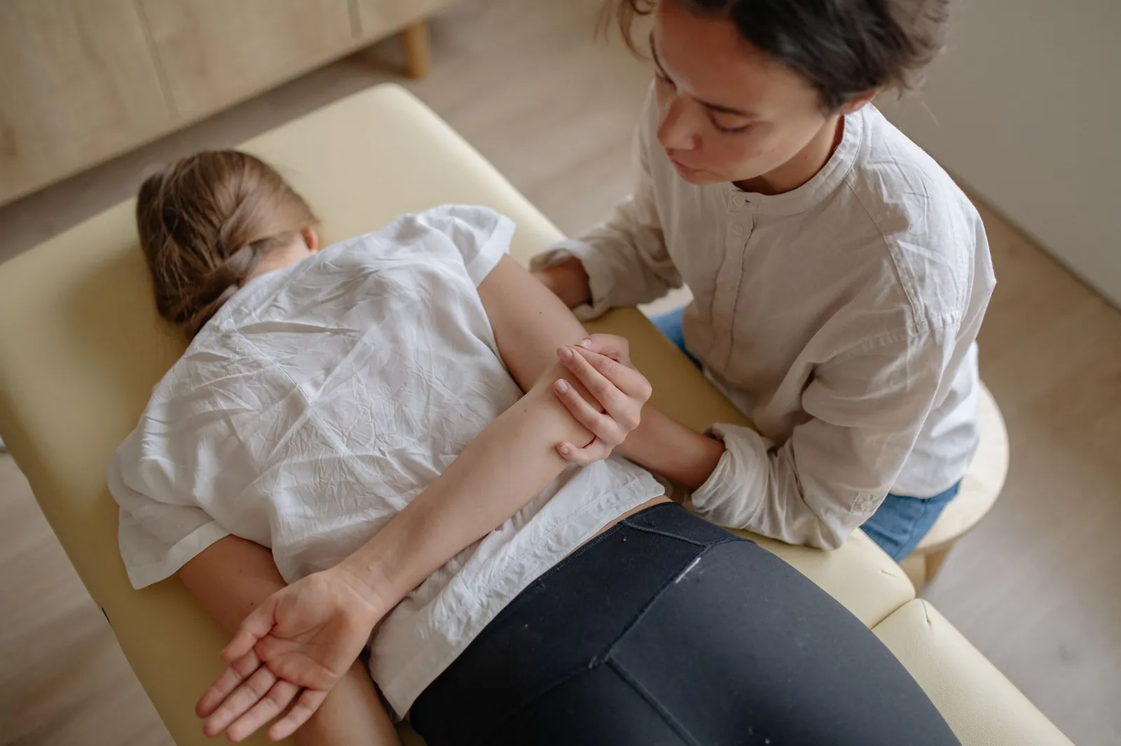 Therapist treating a patient on a massage table