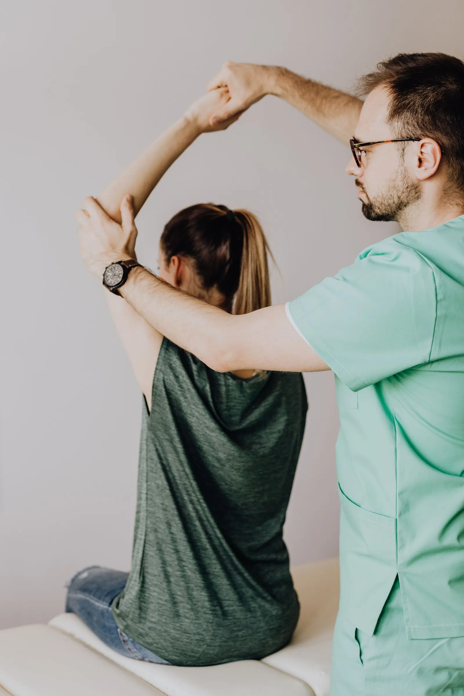 Clinician testing a patient’s shoulder mobility