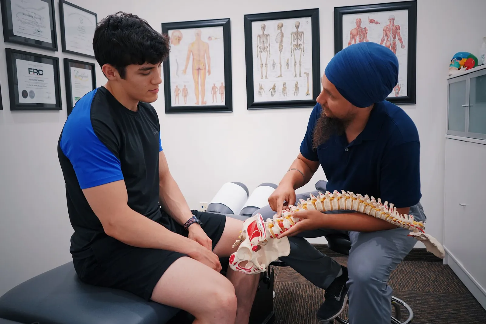 Clinician explaining the spine to a young athlete